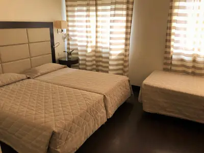 a bedroom with two beds and a window at Hotel Villa Maria Regina in Rome