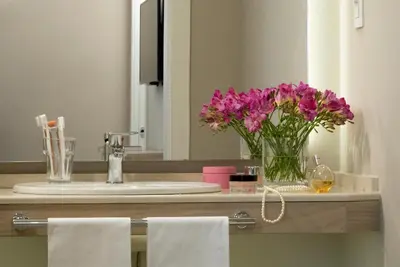 a bathroom with a sink and a vase of purple flowers at Hotel Villa Maria Regina in Rome