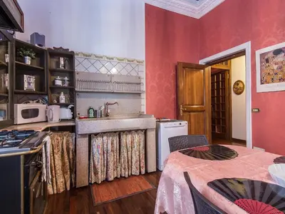 a kitchen with red walls and a sink and a stove at Apartment Spanish Steps by Interhome in Rome