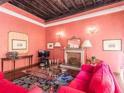 a living room with a red couch and a fireplace at Apartment Spanish Steps by Interhome in Rome