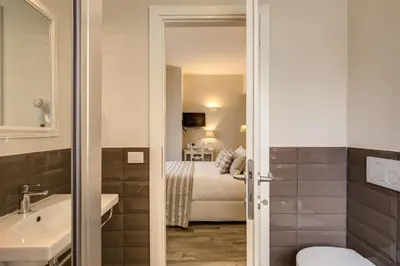 a bathroom with a sink and a bed in a room at Casa Mia Vaticano Guest House in Rome