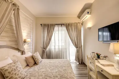 a bedroom with a bed and a desk and a window at Casa Mia Vaticano Guest House in Rome