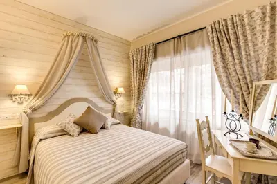 a bedroom with a bed and a desk and a window at Casa Tua Vaticano Guest House in Rome