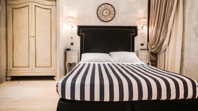 a bedroom with a black and white bed with a clock on the wall at MDM Guesthouse in Rome