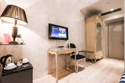 a room with a desk and a television on a wall at MDM Guesthouse in Rome