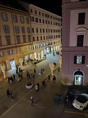 a group of people walking around a street at night at MDM Guesthouse in Rome