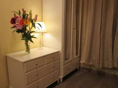 a vase of flowers on a dresser next to a lamp at Trevi Elegance Suite in Rome
