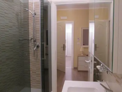 a bathroom with a glass shower and a sink at Trevi Elegance Suite in Rome