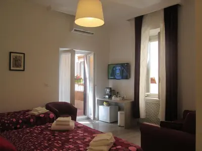 a bedroom with a bed and a chair and a window at Trevi Elegance Suite in Rome