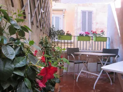 a patio with a table and chairs and plants at Trevi Elegance Suite in Rome
