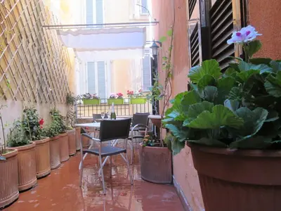 a balcony with tables and chairs and potted plants at Trevi Elegance Suite in Rome
