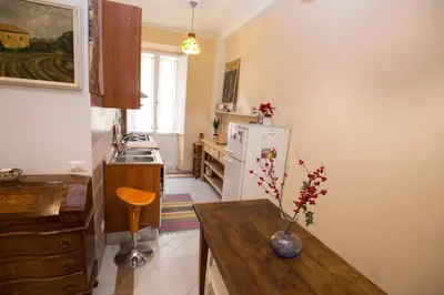 a kitchen with a table and a white refrigerator at Giubiliana in Rome