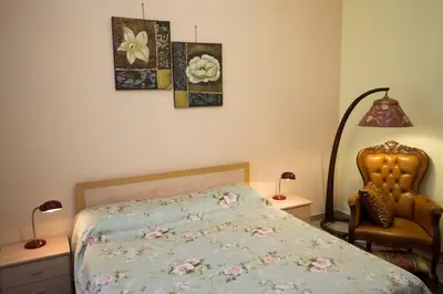 a bedroom with a bed and a chair and two pictures at Giubiliana in Rome