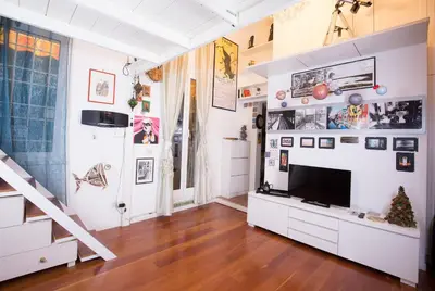 a living room with a television and a staircase at Sweet Dream Penthouse in Rome