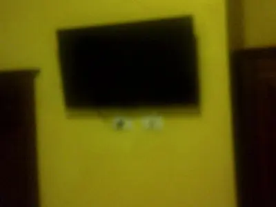 a flat screen television on a yellow wall at 3 Lati di Pitagora B&B in Rome
