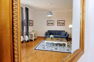 a mirror reflecting a living room with a blue couch at Bellezza Al Colosseo - B&B & Apts in Rome