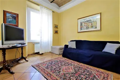 a living room with a blue couch and a tv at Bellezza Al Colosseo - B&B & Apts in Rome