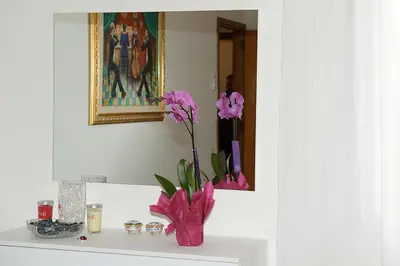 a vase with pink flowers on a shelf in a bathroom at Tintoretto Inn B&B in Rome
