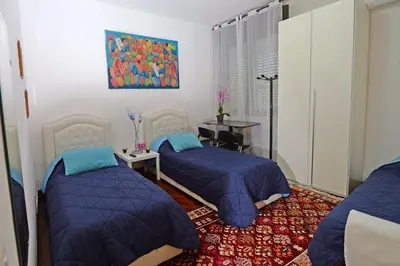 a bedroom with two beds and a table and a painting at Tintoretto Inn B&B in Rome