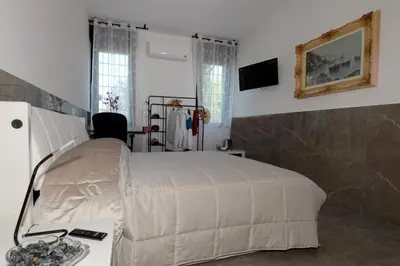 a bedroom with a bed and a table and a television at Tintoretto Inn B&B in Rome