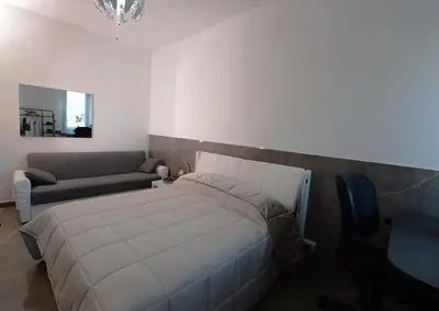 a bedroom with a large bed and a couch at Tintoretto Inn B&B in Rome