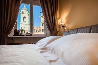 a bedroom with a bed and a window with a clock tower at Hotel Scalinata Di Spagna in Rome