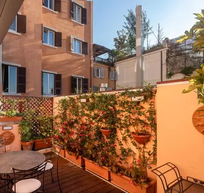 a patio with tables and plants on a wall at Hotel Scalinata Di Spagna in Rome