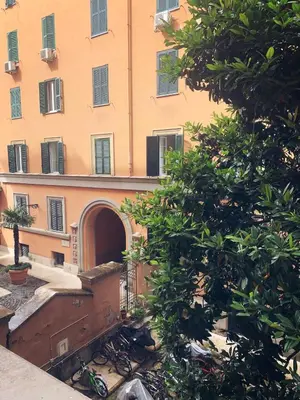 an orange building with an archway in front of a tree at Mc - Piazza Mancini in Rome