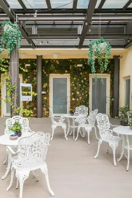 a group of white tables and chairs on a patio at Borghetto Guest House in Rome