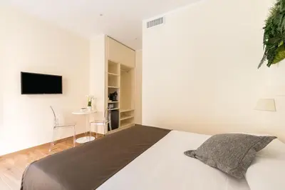 a bedroom with a bed and a tv on a wall at Borghetto Guest House in Rome