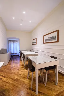 a row of tables in a room with white walls at Lory House in Rome