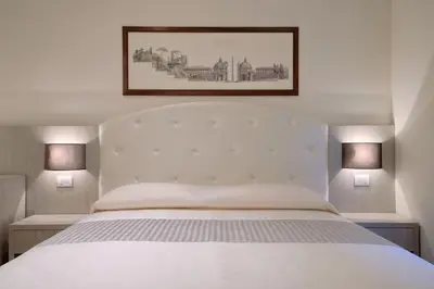a bedroom with a white bed with two lamps at Lory House in Rome