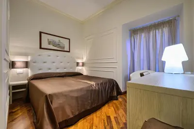 a bedroom with a bed and a table with a lamp at Lory House in Rome