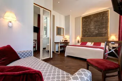 a hotel room with two beds and a mirror at Hotel Nazionale in Rome