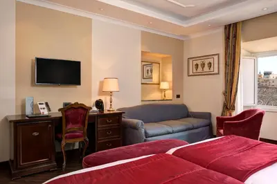 a hotel room with a bed and a couch at Hotel Nazionale in Rome