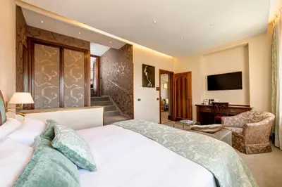 a bedroom with a bed and a desk and a television at Hotel Nazionale in Rome