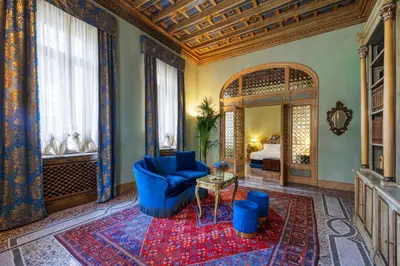 a living room with a blue couch and a mirror at Hotel Locarno in Rome