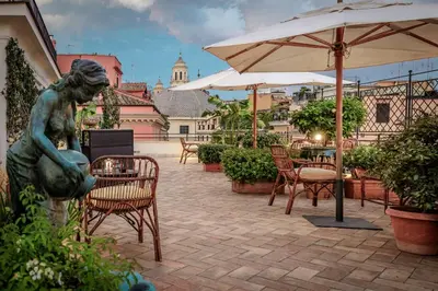 a statue of a woman sitting under an umbrella on a patio at Hotel Locarno in Rome