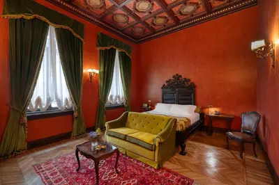 a bedroom with a bed and a couch and a table at Hotel Locarno in Rome