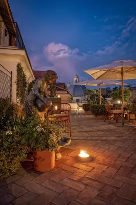 a statue of a woman sitting on a bench on a patio at Hotel Locarno in Rome