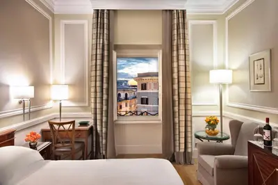 a hotel room with a bed and a desk and a window at Rome Marriott Grand Hotel Flora in Rome