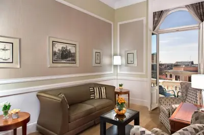 a living room with a couch and a window at Rome Marriott Grand Hotel Flora in Rome