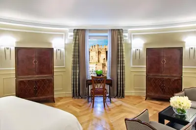 a bedroom with a bed and a desk and a chair at Rome Marriott Grand Hotel Flora in Rome