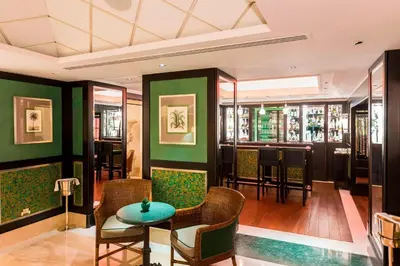 a restaurant with green walls and a table and chairs at Rome Marriott Grand Hotel Flora in Rome