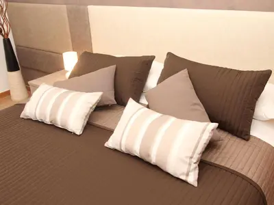 a bed with four pillows on top of it at Dormi a Roma in Rome