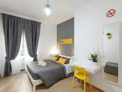 a bedroom with a bed and a white table and chair at Dormi a Roma in Rome