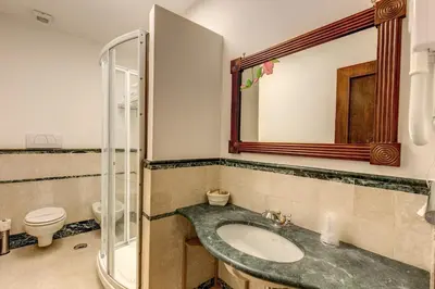 a bathroom with a sink and a toilet and a mirror at Apollo Apartments Colosseo in Rome