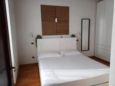 a bedroom with a white bed and a mirror at Apollo Apartments Colosseo in Rome