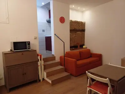 a living room with a chair and a couch and stairs at Apollo Apartments Colosseo in Rome