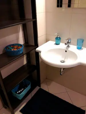 a bathroom with a white sink and a shelf at B&B Stelle Di Roma in Rome